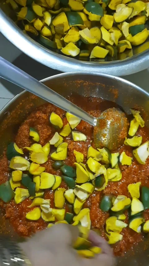 Transferring Mango Pieces into Spiced Pickle Base by Hand Stock Footage 337713596