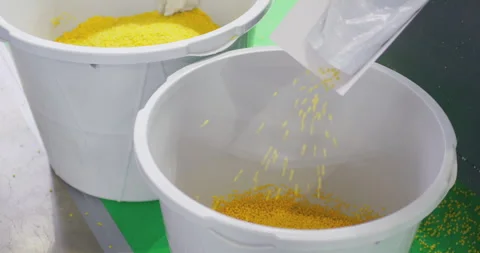 Transferring plastic granules into a container. Stock Footage 329180730