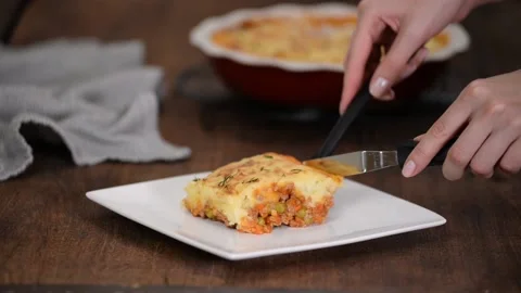 Transferring steaming hot, freshly baked shepherds pie, from a pan to a plate Stock Footage 165235598