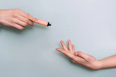 Transferring vape from one hand to another against light background Stock Photos
