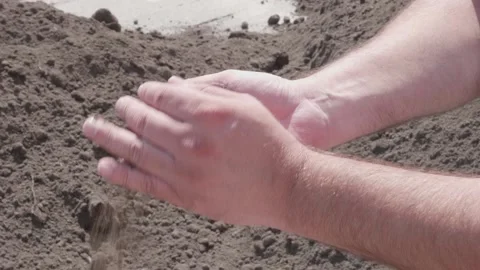 Transfers sand in his hands on the construction site Stock Footage 132491316