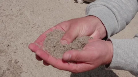 Transfers sand in his hands on the construction site Stock Footage 132494962