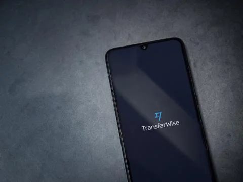 TransferWise app launch screen with logo on the display of a black mobile sma Stock Photos