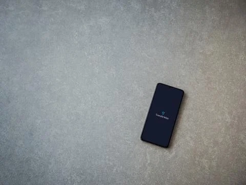 TransferWise app launch screen with logo on the display of a black mobile sma Stock Photos