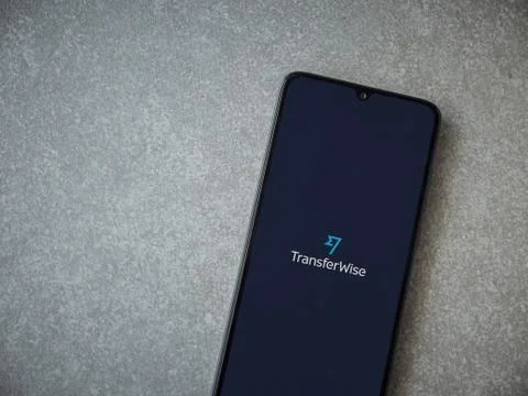 TransferWise app launch screen with logo on the display of a black mobile sma Stock Photos