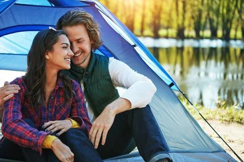 Transform your camping into a romantic getaway. an adventurous couple out Stock Photos