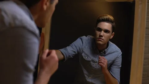 Transgender man looking in mirror, feels ugly or weird being male, insecurities Stock Footage 114399379