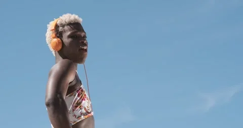 Transgender person dancing while listening to music with headphones outdoors. Stock Footage 245079462