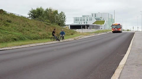 Transit bus passing bmxers Stock Footage 8766055