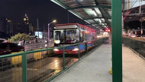 Transit bus pulling away from EDSA Carousel station at night 4K 30fps 库存影片 337950392