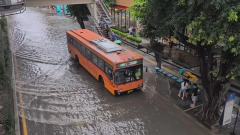 Transit bus transports wet passengers on flooded Bangkok city streets Stock Footage 346926792