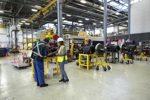 Transit manager and worker fixing equipment in maintenance facility Stock Photos