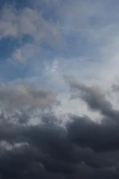 Transition from dark clouds to bright sky, weather change, vertical shot, clo Stock Photos