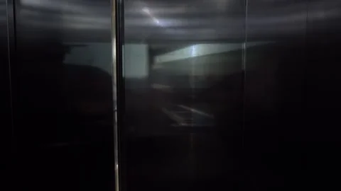 Transition from a Reflective Elevator Interior to a Bright Corridor Overlooking Stock Footage 317905395