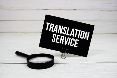 Translation Services text message on paper card with magnifying glass on wo.. Stock Photos