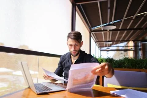 Translator sorting papers and closing laptop lid. Stock Photos