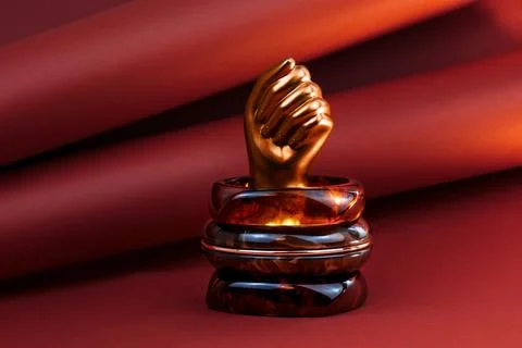 Translucent amber cuff bracelet displayed on a sculptural gold hand Stock Photos