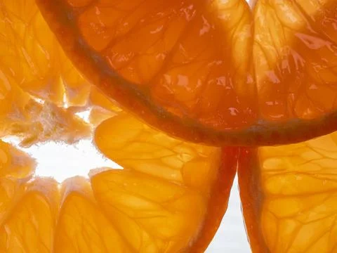 Translucent backlit orange slices close-up macro texture background Foto stock