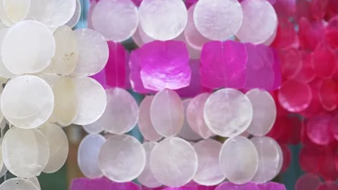 Translucent capiz shell hanging decorations swaying gently in the wind Stock Footage 334718272