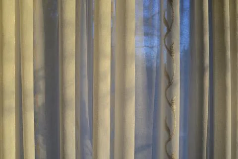 Translucent curtains behind which the sky and trees Foto stock