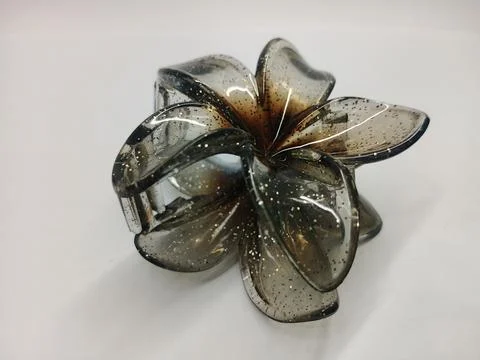Translucent dark grey flower claw hair clip with glitter effect on Stock Photos