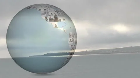 Translucent globe sphere hovering over coastal scene displaying animated Stock Footage 307429645