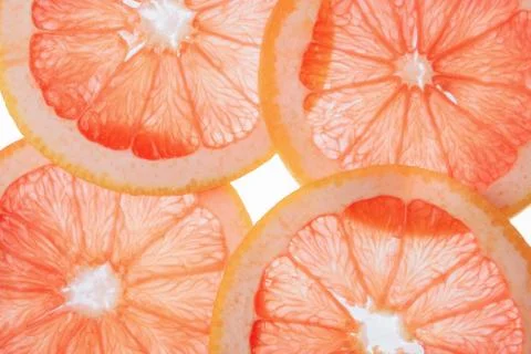 Translucent grapefruit slices on a white background, citrus fruit slices Stock Photos