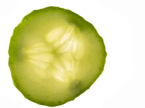 Translucent green cucumber slice backlit and isolated on white background Foto stock