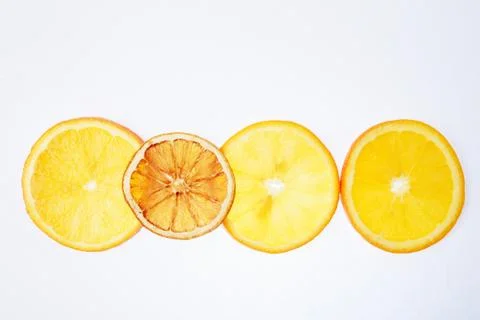 Translucent orange slices on a white background, dry and ripe slices together 库存照片
