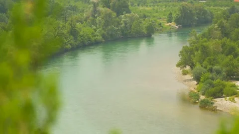 Translucent river surrounded by trees crossing the green countryside of Bosnia Stock Footage 241679643