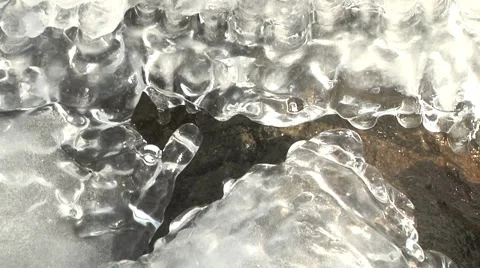 Translucent Shiny Ice Formations Frozen to Rocks over Lake Waves Stock Footage 2829795