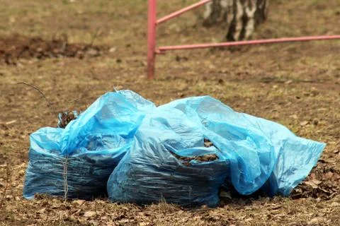 Translucent trash bag pile on the side walk Foto stock