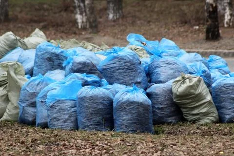Translucent trash bag pile on the side walk Foto stock