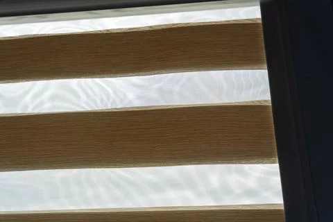 Translucent window blinds allowing soft light to filter through, creating a warm 写真素材