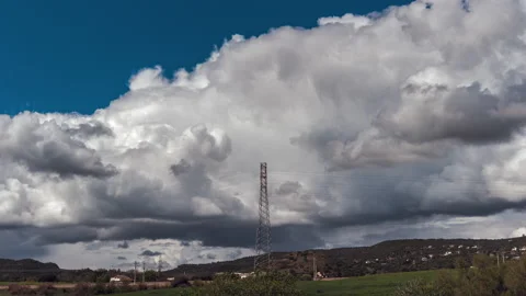 Transmission Tower and Clouds Growing Over Green Field Landscape - Time Lapse Vídeo Stock 146305601