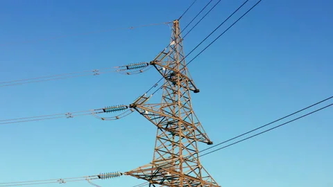 Transmission tower supporting an overhead high voltage power line Stock Footage 138742915