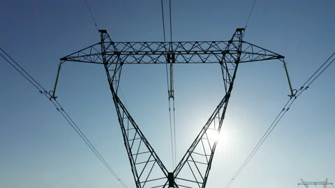 Transmission tower supporting an overhead high voltage power line silhouette Stock Footage 139024556