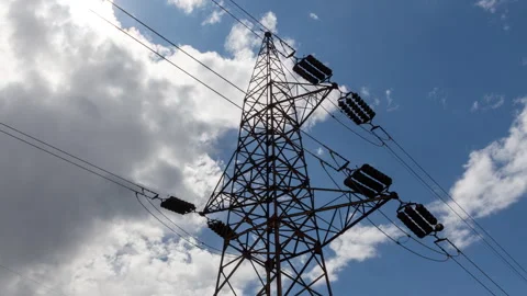 Transmission tower supporting an overhead high voltage power line - time lapse Stock Footage 309415737