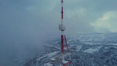 Transmit mast in the clouds above the snowy city Stock Footage 172535864