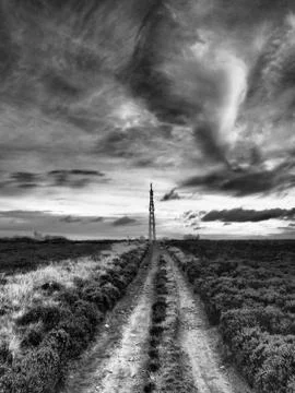 Transmitter mast on moors under brooding sky shot in black and white Stock Photos