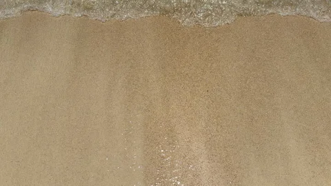 Transparent and smooth waves roll easily and calmly into the sandy shore. Stock Footage 303588772