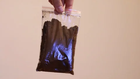 Transparent bag with brown powder Vidéo 107938348