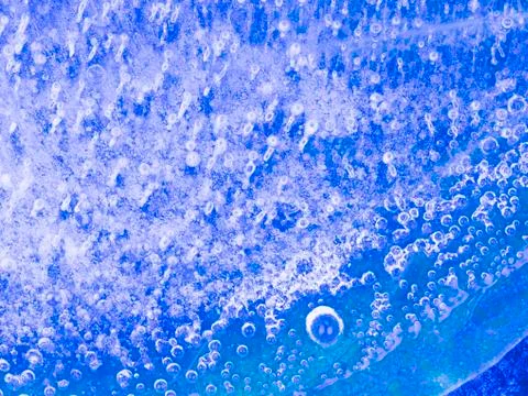 Transparent blue ice with bubbles Stock Photos
