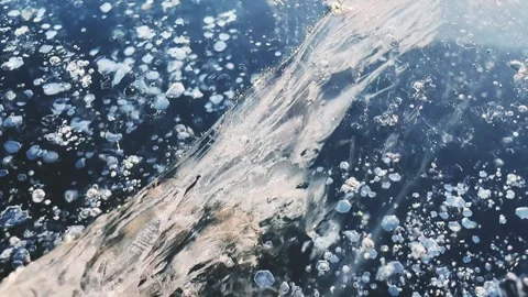 Transparent blue ice with cracks and bubbles on the frozen lake. Stock-Footage 298178226