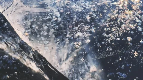 Transparent blue ice with cracks and bubbles on the frozen lake. 스톡 동영상 298178322