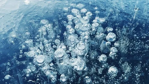 Transparent blue ice with cracks and bubbles on the frozen lake. 스톡 동영상 298178477