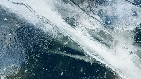 Transparent blue ice with cracks and bubbles on the frozen lake. Video stock 298179907