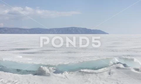 Transparent blue ice hummocks on lake Baikal shore. Siberia winter landscape Stock Photos