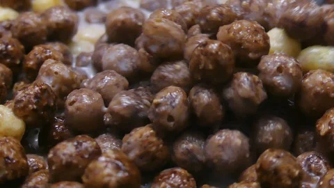 Transparent bowl with chocolate corn flakes. Eating corn balls breakfast with Stockbeeldmateriaal 107901580