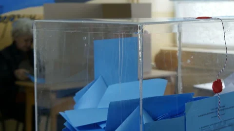 Transparent box with blue ballots close up, voter inserting ballot in box. Stock Footage 62608330